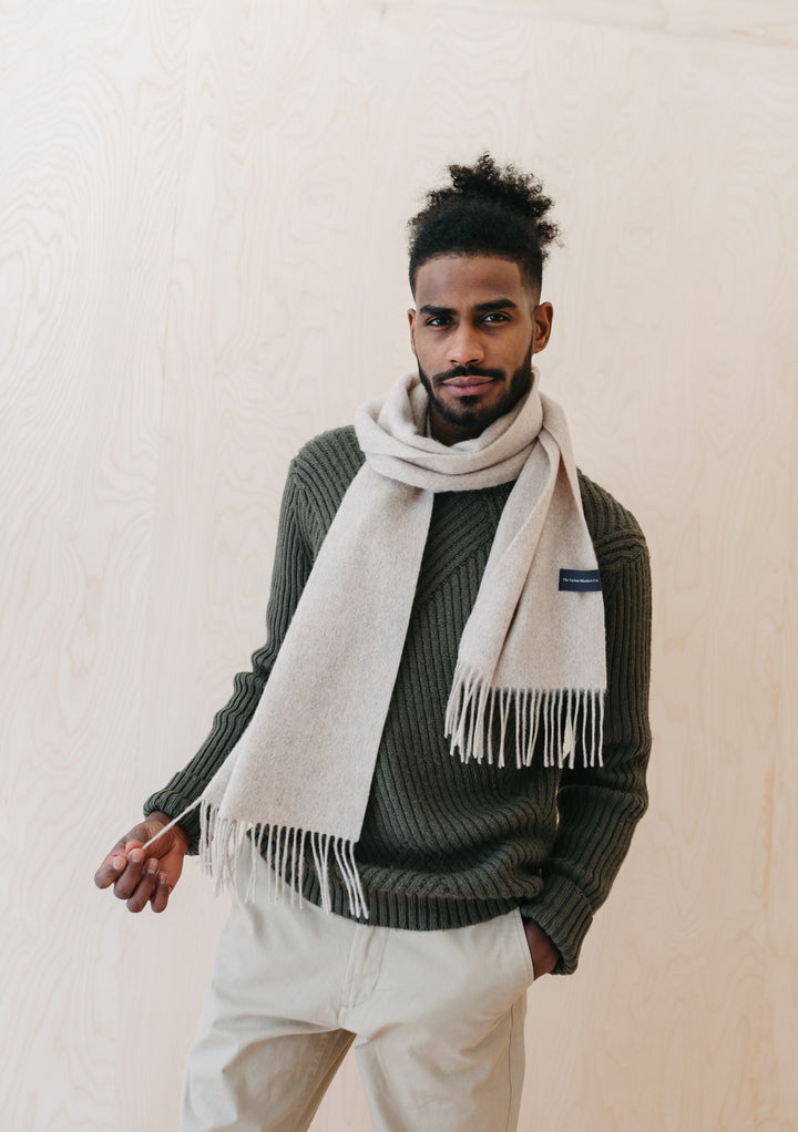 TBCo Mens Lambswool Scarf in Oatmeal Melange styled with green knit jumper, showing fringed edges and classic drape