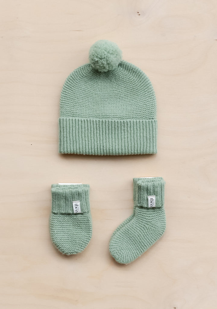 TBCo Merino Wool Baby Accessories Bundle in pistachio green featuring knitted beanie with pom-pom, mittens and socks