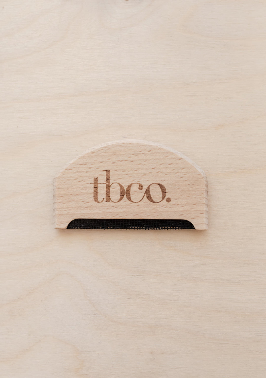 TBCo wooden wool comb made from natural beechwood featuring brand logo, designed for gentle wool care and depilling