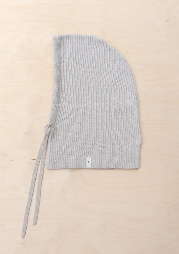 TBCo Merino Hood in Oatmeal Melange shown flat, displaying ribbed knit texture and tie fasteners in light grey wool
