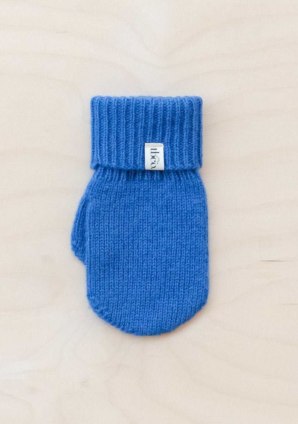 TBCo Merino Wool Kids Mittens in bright blue with ribbed cuff, showcasing classic knit pattern and brand label