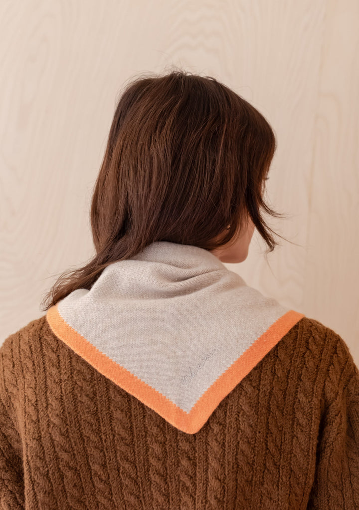 TBCo Merino Triangle Scarf in camel with apricot edging shown draped over brown cable knit jumper, back view styling