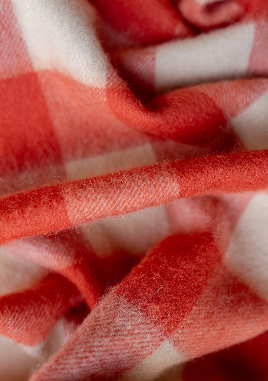 Close-up detail of TBCo Lambswool Scarf in Orange Gingham showing soft woven texture and vibrant check pattern