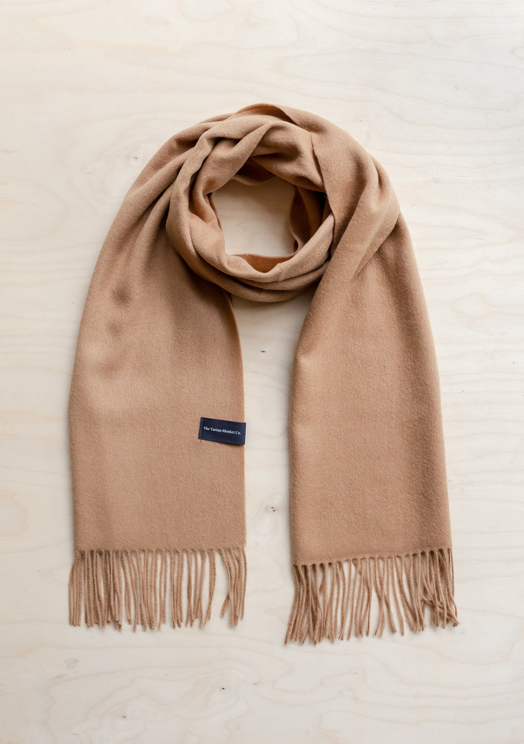 TBCo Men's Lambswool Scarf in Camel, featuring soft fringed edges and classic design, displayed flat against cream background