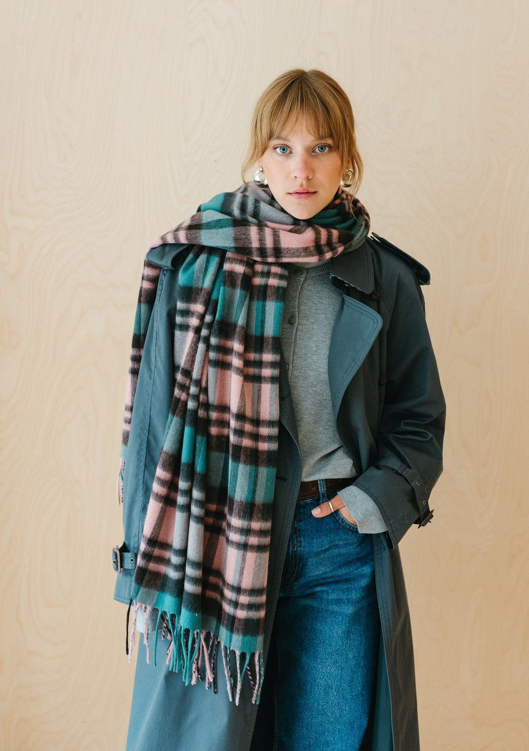 TBCo Lambswool Blanket Scarf in Green Tartan Check styled with teal coat and denim, showing fringed edges and plaid pattern