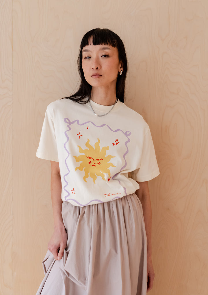 TBCo Cotton T-Shirt in Ecru Sun featuring cheerful yellow sun illustration with lilac border on cream cotton base