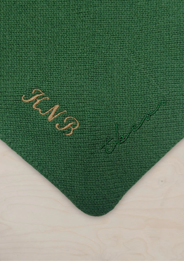Close-up of personalised embroidery on TBCo Merino Wool Triangle Scarf in Navy Ruffle with green wool fabric texture