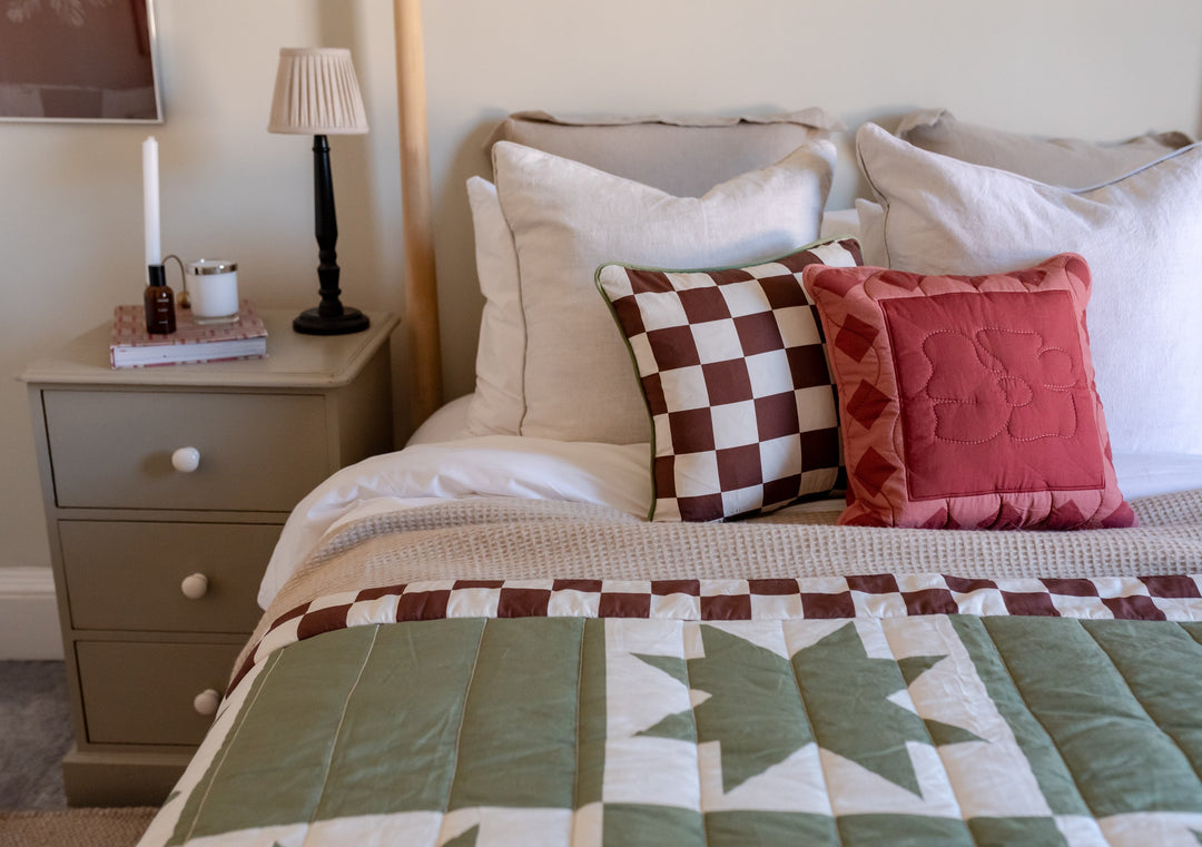 Bed styled with TBCo green quilted cotton throw and matching cushions.