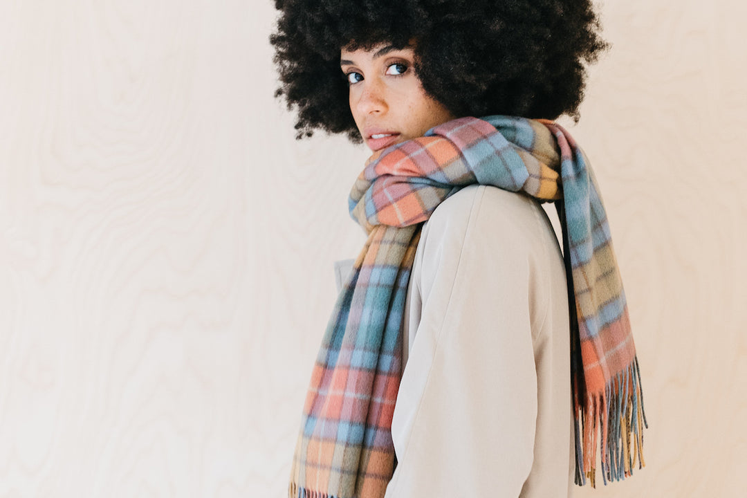 A model wears a TBCo lambswool scarf in a multicoloured buchanan antique tartan design.