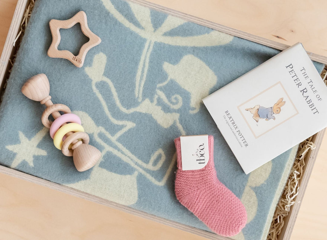 TBCo cashmere and merino beanie hats in blue, green, grey and pink, stacked high on a little girl's head.  