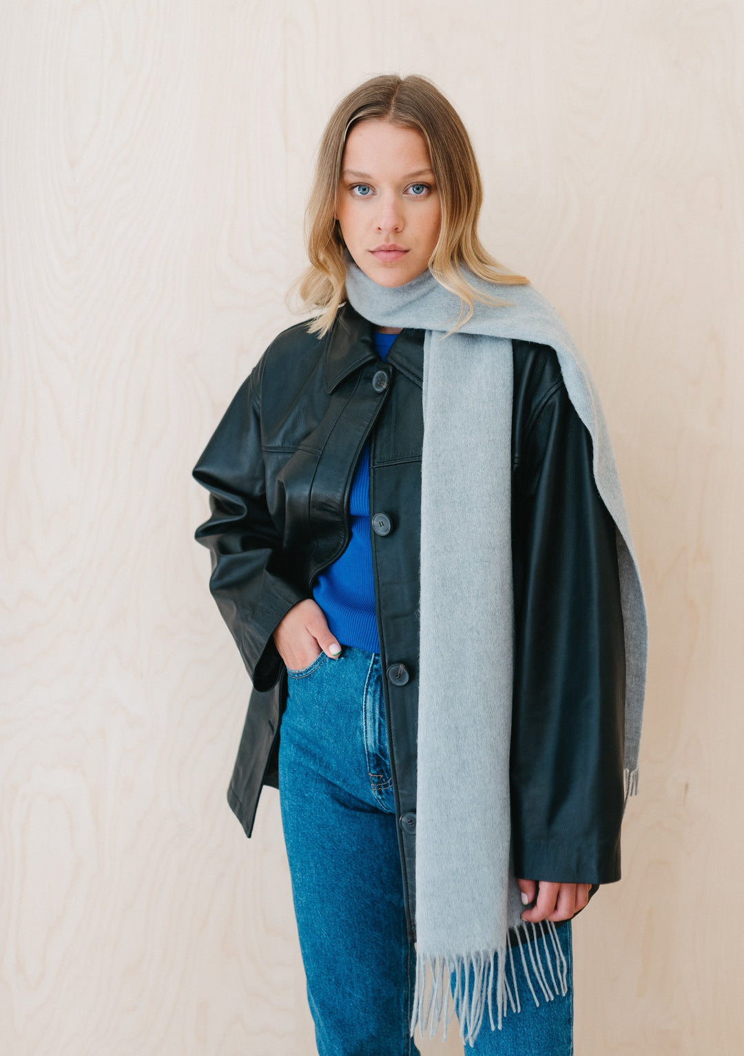 TBCo Lambswool Scarf in Light Grey Melange styled with leather jacket and denim, showcasing soft texture and fringed detail