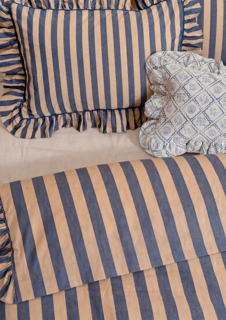 Pair of Cotton Pillowcases in Navy Stripe by TBCo featuring soft navy and beige stripes with ruffled edges on relaxed bedding setting