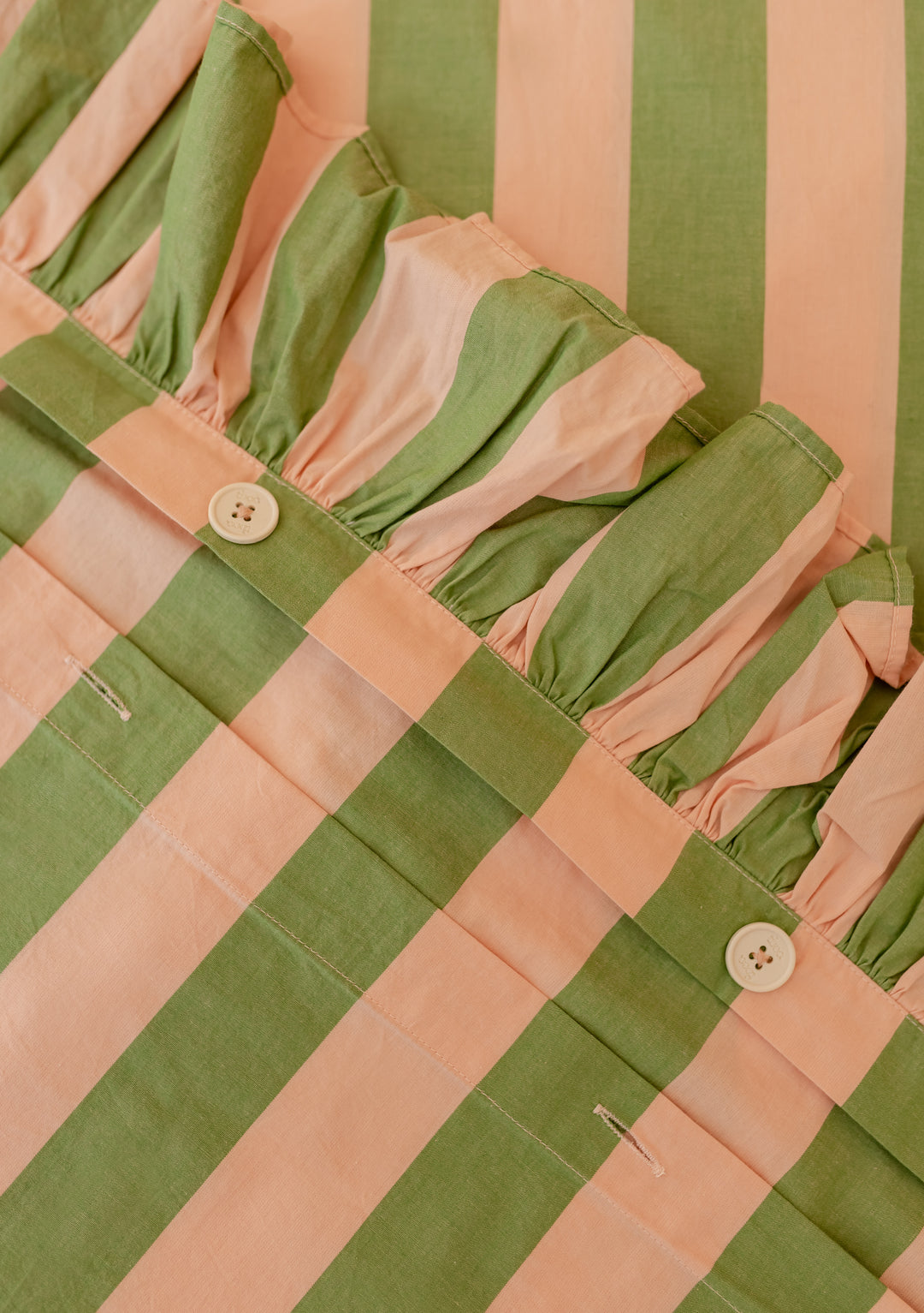 Close-up of TBCo Cotton Duvet Cover & Pillowcases Set in Green Stripe showing ruffle edge and button details
