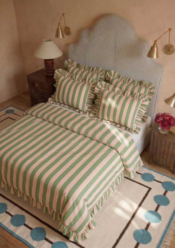 Cotton Duvet Cover & Pillowcases Set in Green Stripe by TBCo with ruffled edges styled on bed with soft pastel décor
