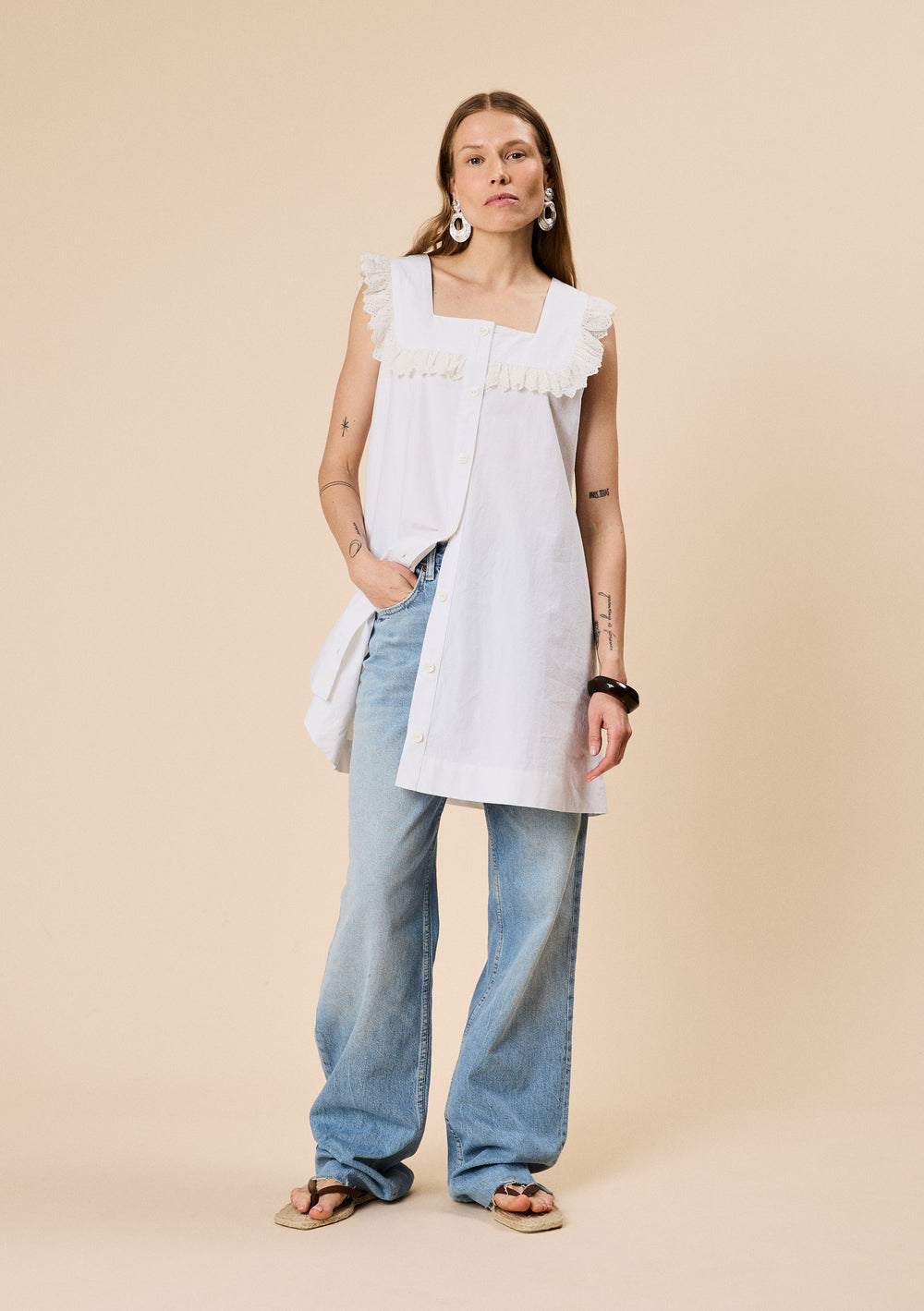 Woman wearing TBCo Cotton Broderie Sleeveless Dress in White made with natural and recycled fibres, women-founded, designed to make an impact