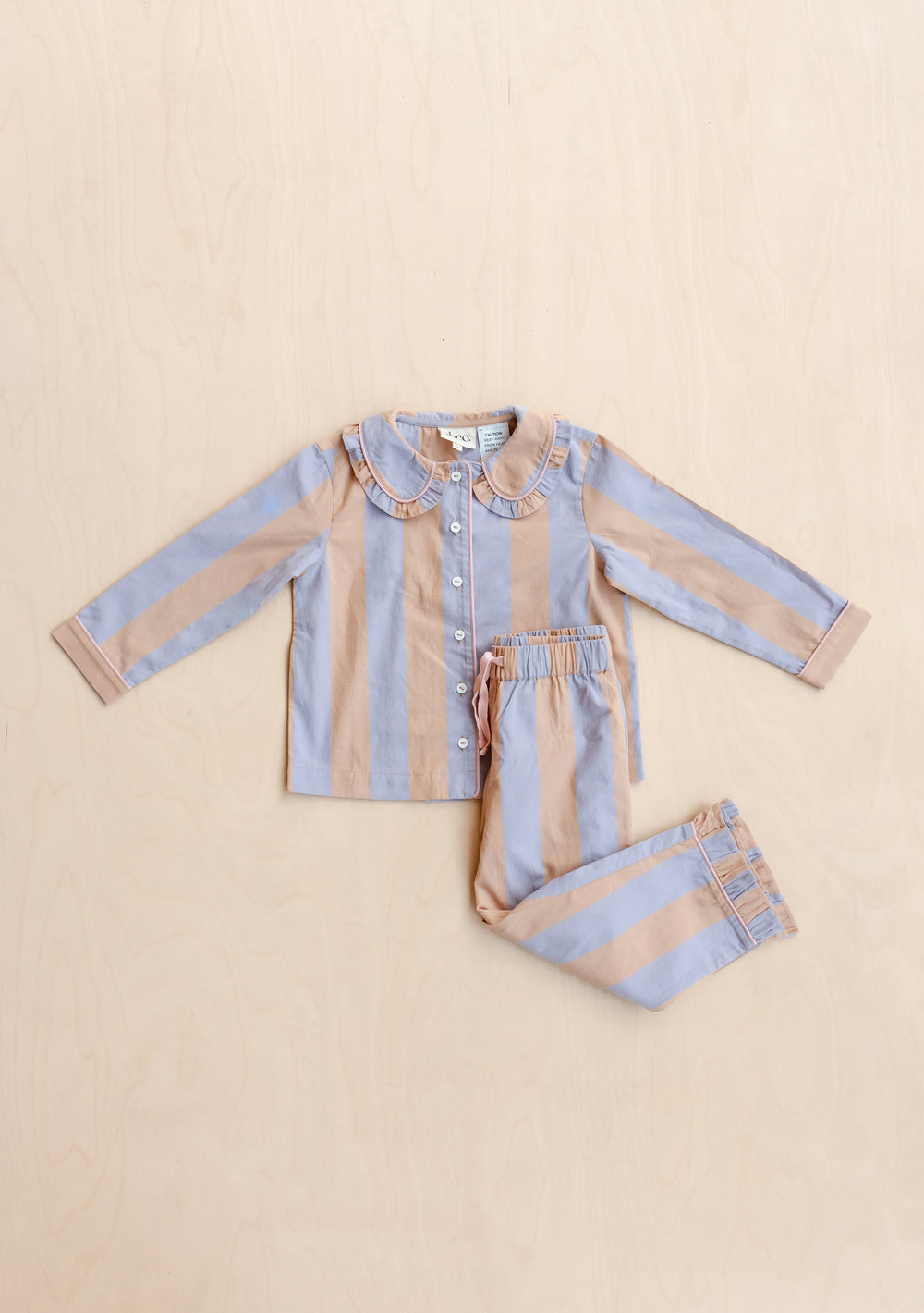 TBCo Cotton Kids Pyjamas in orange and lilac stripe with ruffled collar, laid flat showing top and bottom set