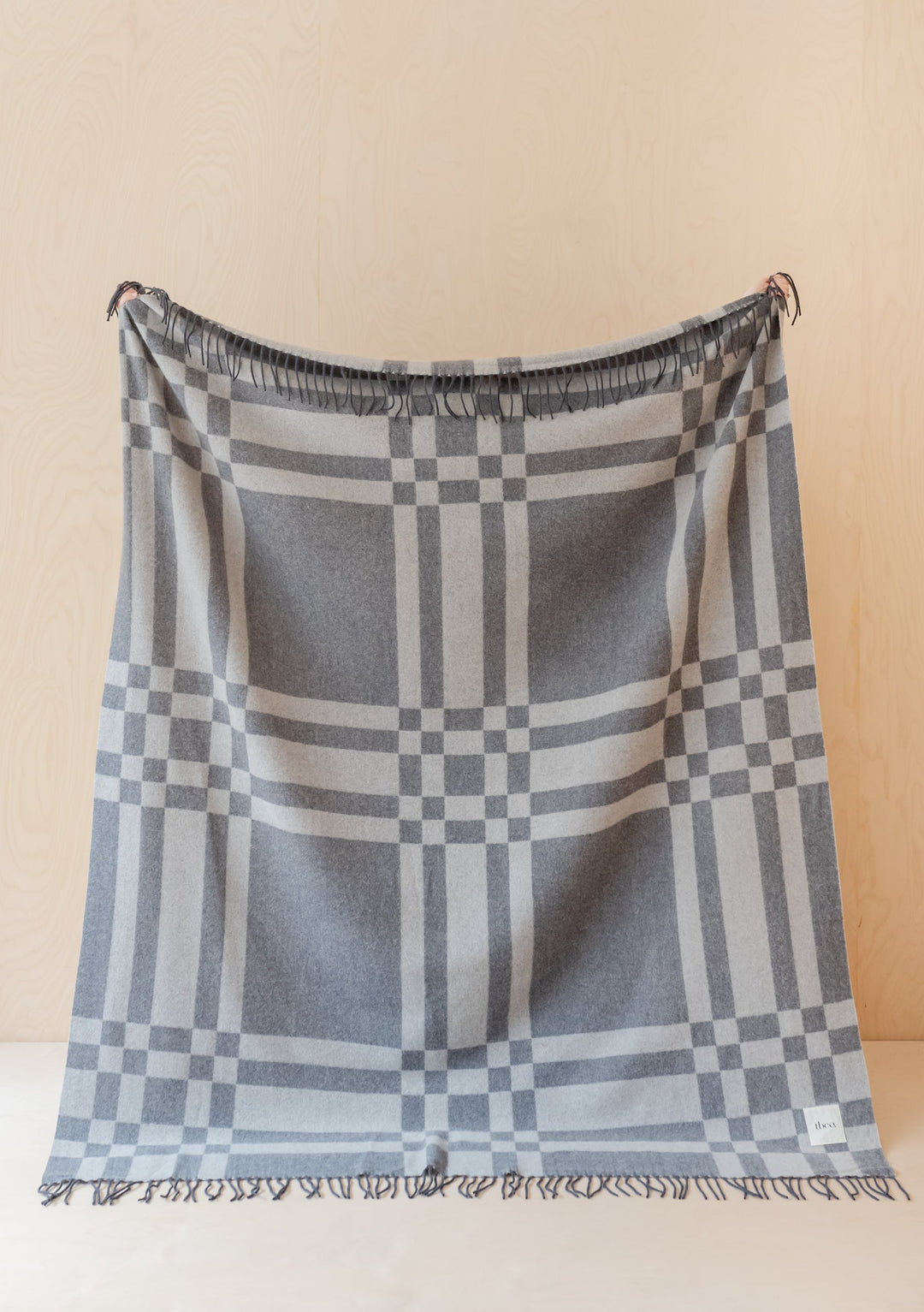 TBCo Lambswool Blanket in grey pillar check pattern displayed flat with fringed edges showing geometric checkered design