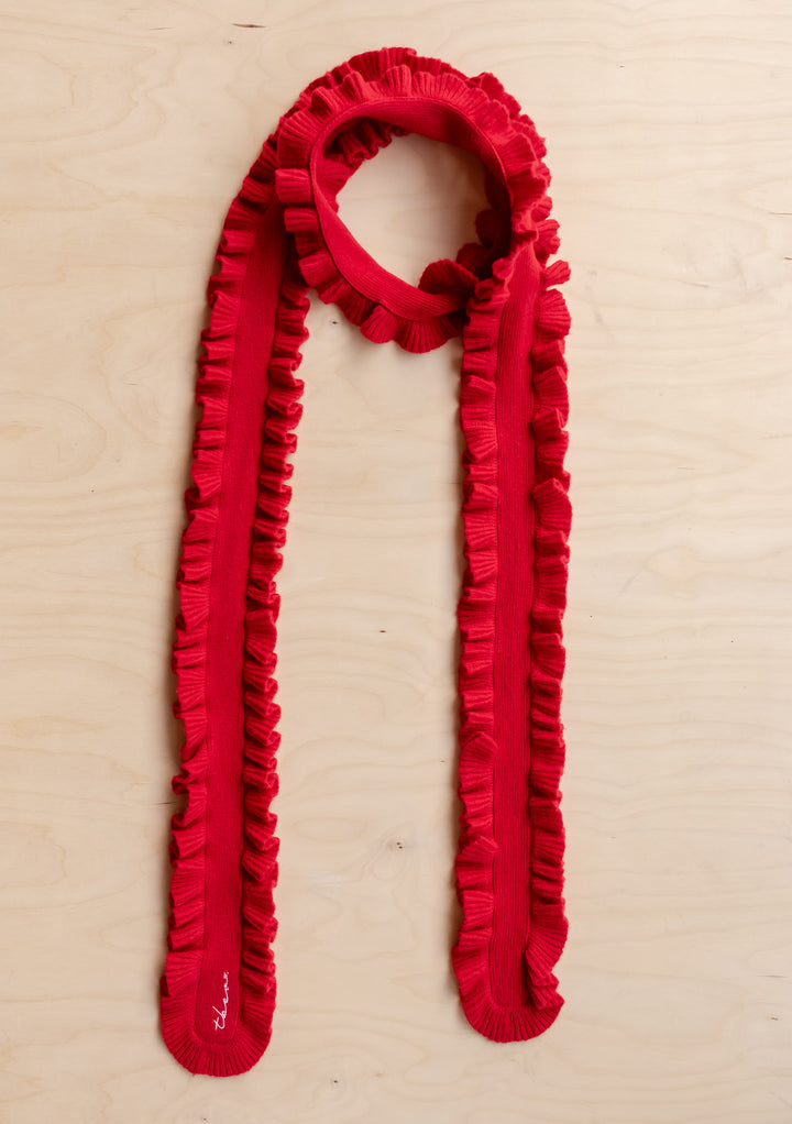 TBCo Merino Wool Skinny Scarf in Red Ruffle laid flat showing vibrant red colour and delicate ruffled trim on wooden surface