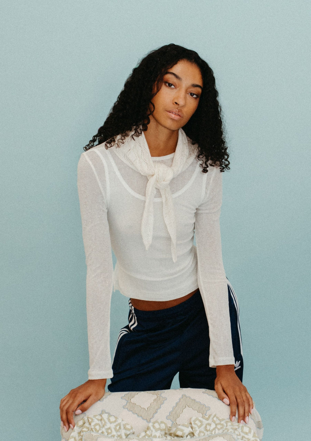 Model wearing TBCo Merino Wool Triangle Scarf in White Pointelle tied at the neck with light knit texture