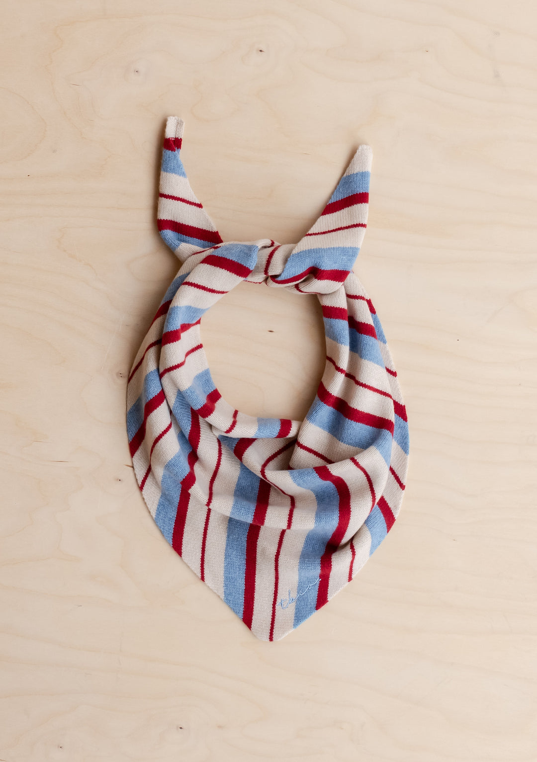 TBCo Merino Wool Triangle Scarf in Blue & Red Stripe with irregular stripes tied on light wood background