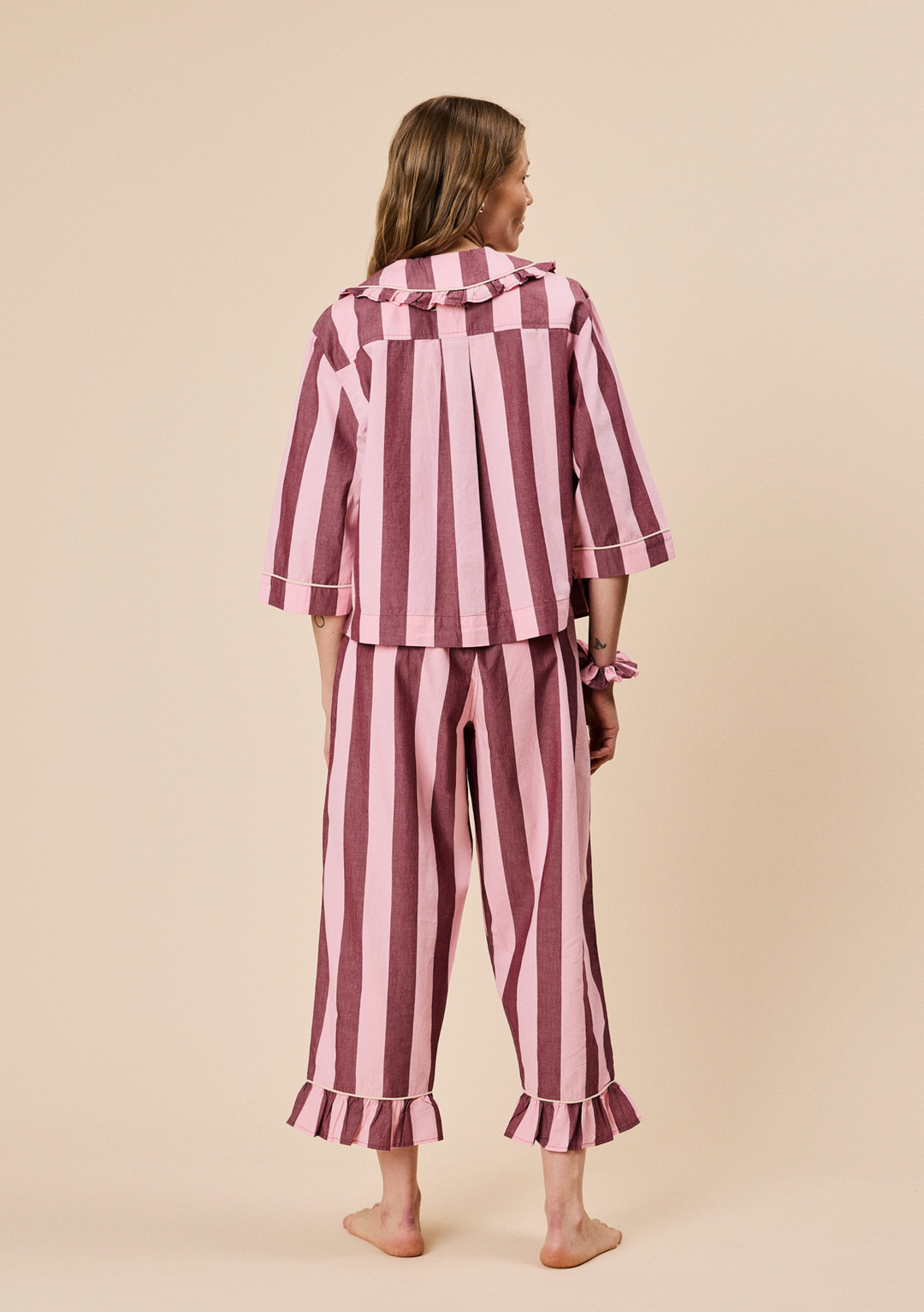 Back view of TBCo Cropped Cotton Pyjamas in Pink & Burgundy Stripe with ruffled collar and frilled cropped hem trousers