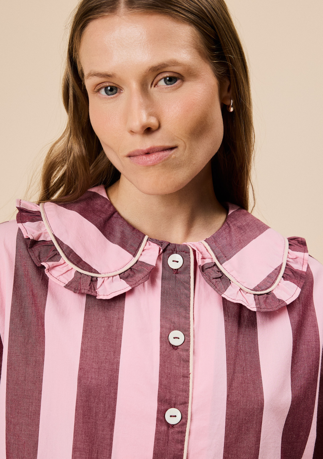 Close-up of TBCo Cropped Cotton Pyjamas in Pink & Burgundy Stripe featuring ruffled collar and button front detail