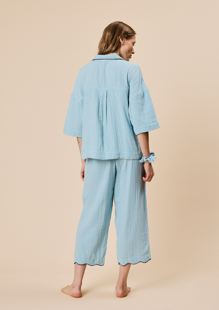 Woman seen from behind wearing TBCo Cropped Cotton Pyjamas in Blue with relaxed fit and cropped wide-leg trousers