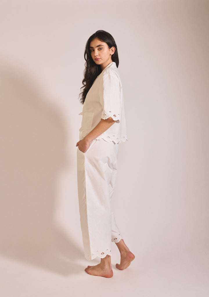 Side view of model wearing TBCo Cropped Cotton Pyjamas in White Shell with delicate eyelet trim on sleeves and ankles