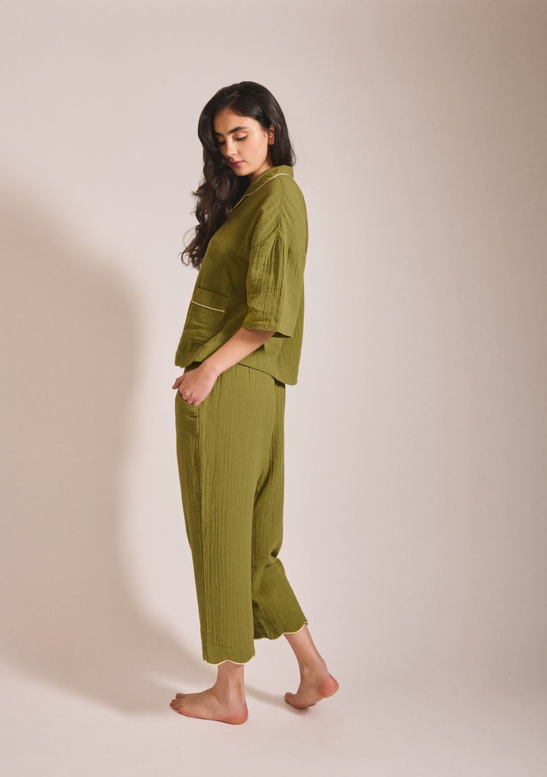 Model in portrait shot wearing TBCo Cropped Cotton Pyjamas in Green with yellow piping, gallery position 3
