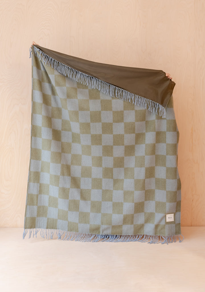 Portrait view of TBCo Recycled Wool Picnic Blanket in Green & Blue Checkerboard showing fringe and reversible side details