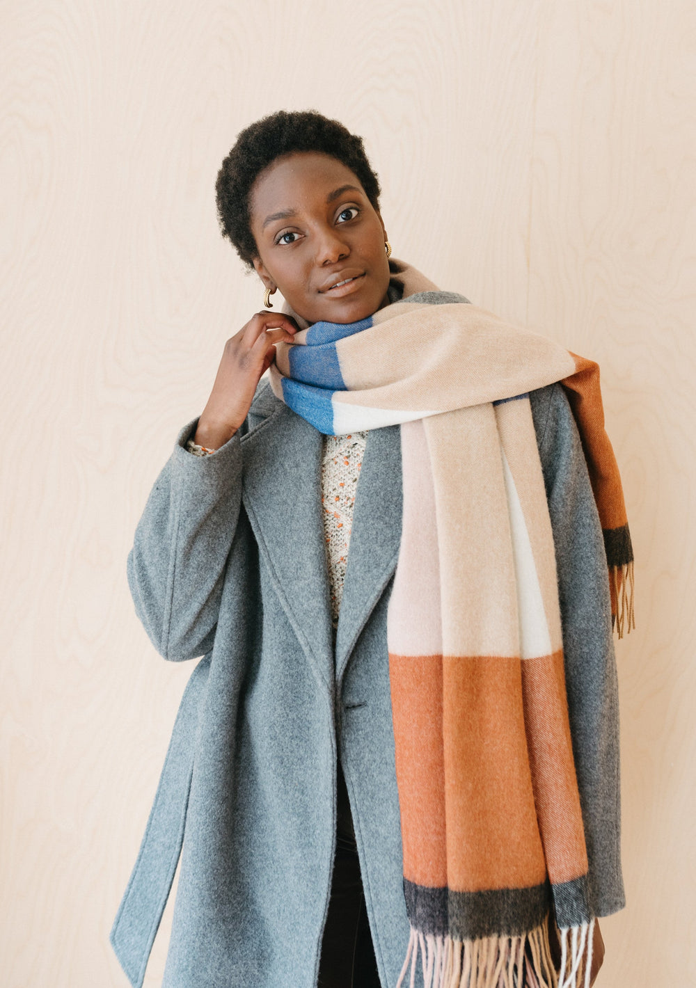 TBCo Lambswool Blanket Scarf in Camel Modern Check styled with grey winter coat, showing soft woollen texture and fringed edges