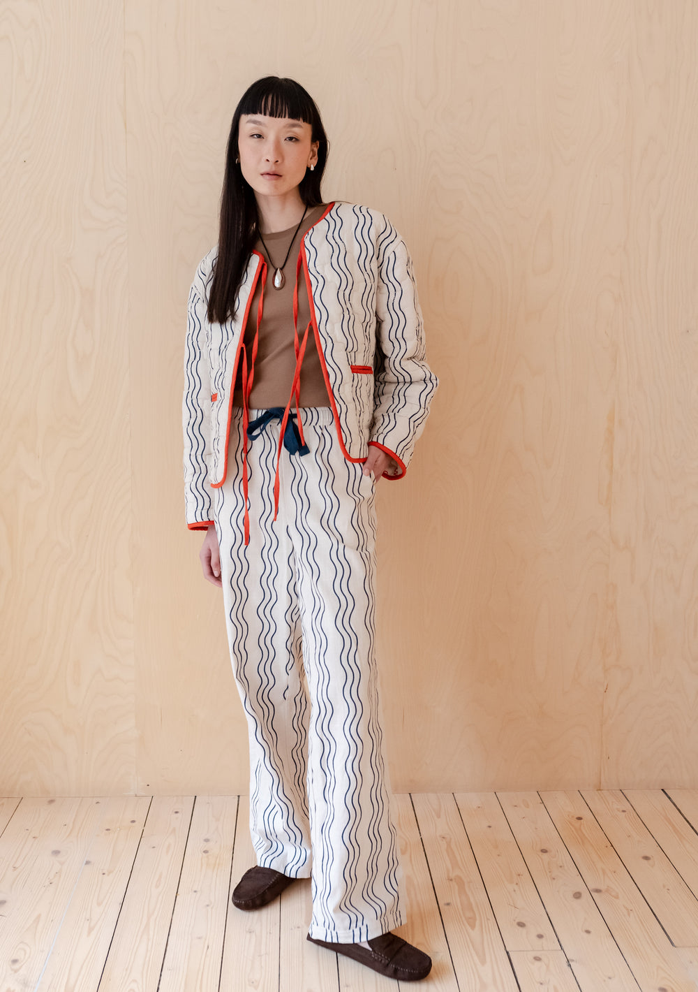 Model wearing TBCo Cotton Trousers in Blue Wave with wave pattern and elastic waistband in relaxed fit