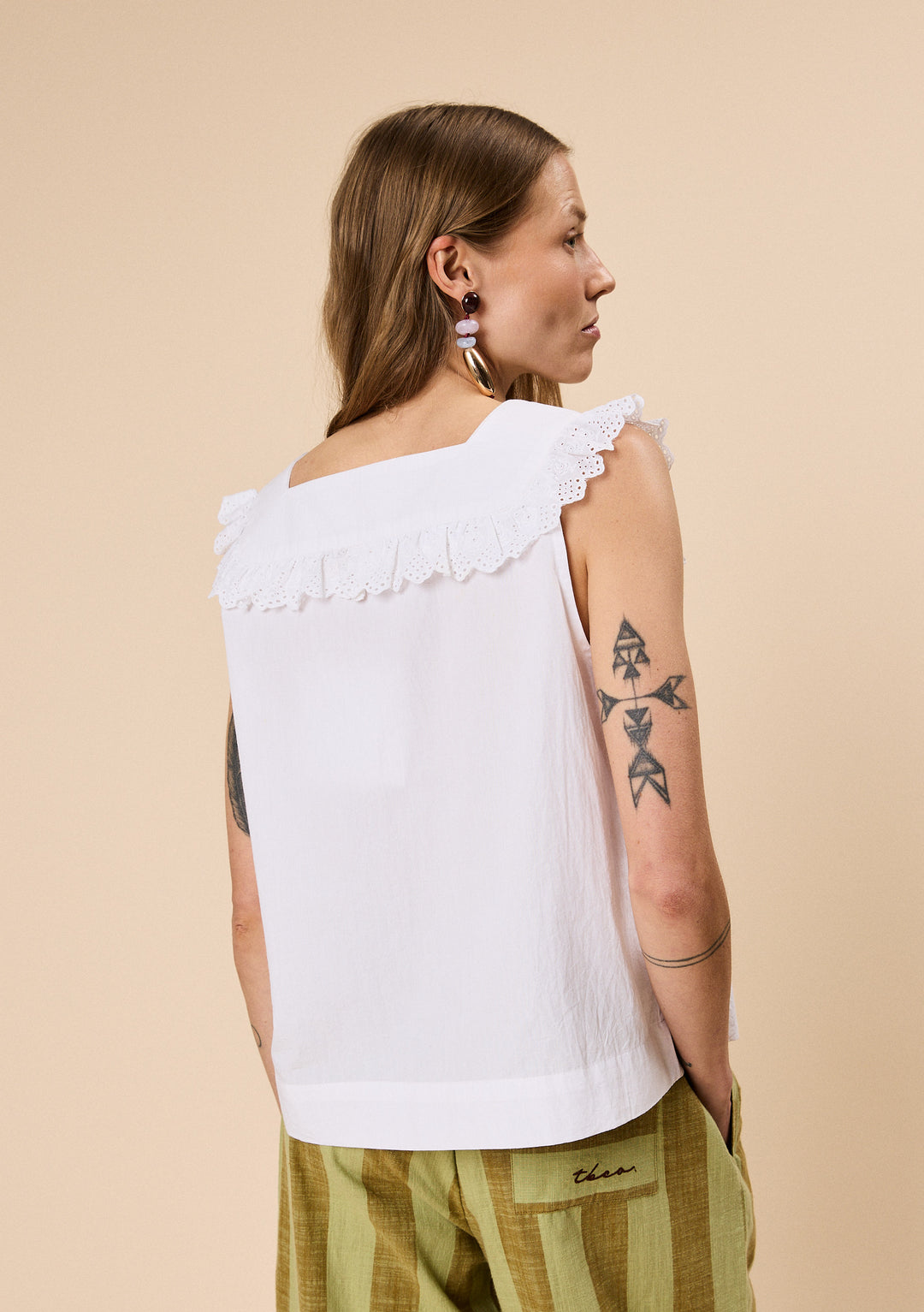 Woman wearing TBCo Cotton Broderie Sleeveless Top in White with natural and recycled fibres, Certified B-Corp, women-founded, designed to make an impact